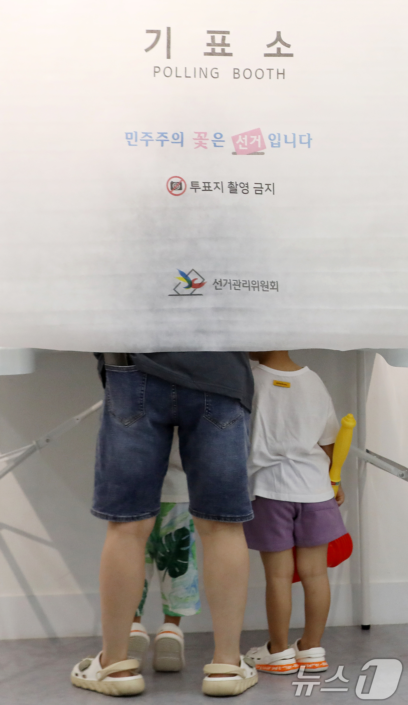 (부산=뉴스1) 윤일지 기자 = 제9회 전국동시지방선거 및 국회의원 재·보궐선거일인 3일 부산 부산진구청에 마련된 부암제1동제4투표소에서 아이들이 엄마가 투표하는 모습을 지켜보고 …