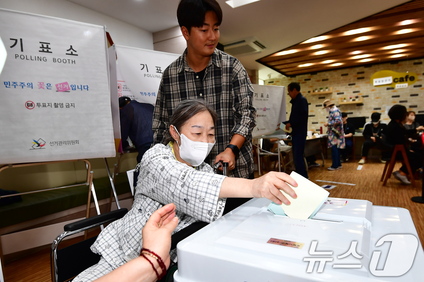 (포항=뉴스1) 최창호 기자 = 제9회 전국동시지방선거 본 투표일인 3일 오전 경북 포항시 북구 죽도동 포항고용복지플러스센터에 마련된 투표소에서 휠체어를 탄 유권자가 선거사무원의 …