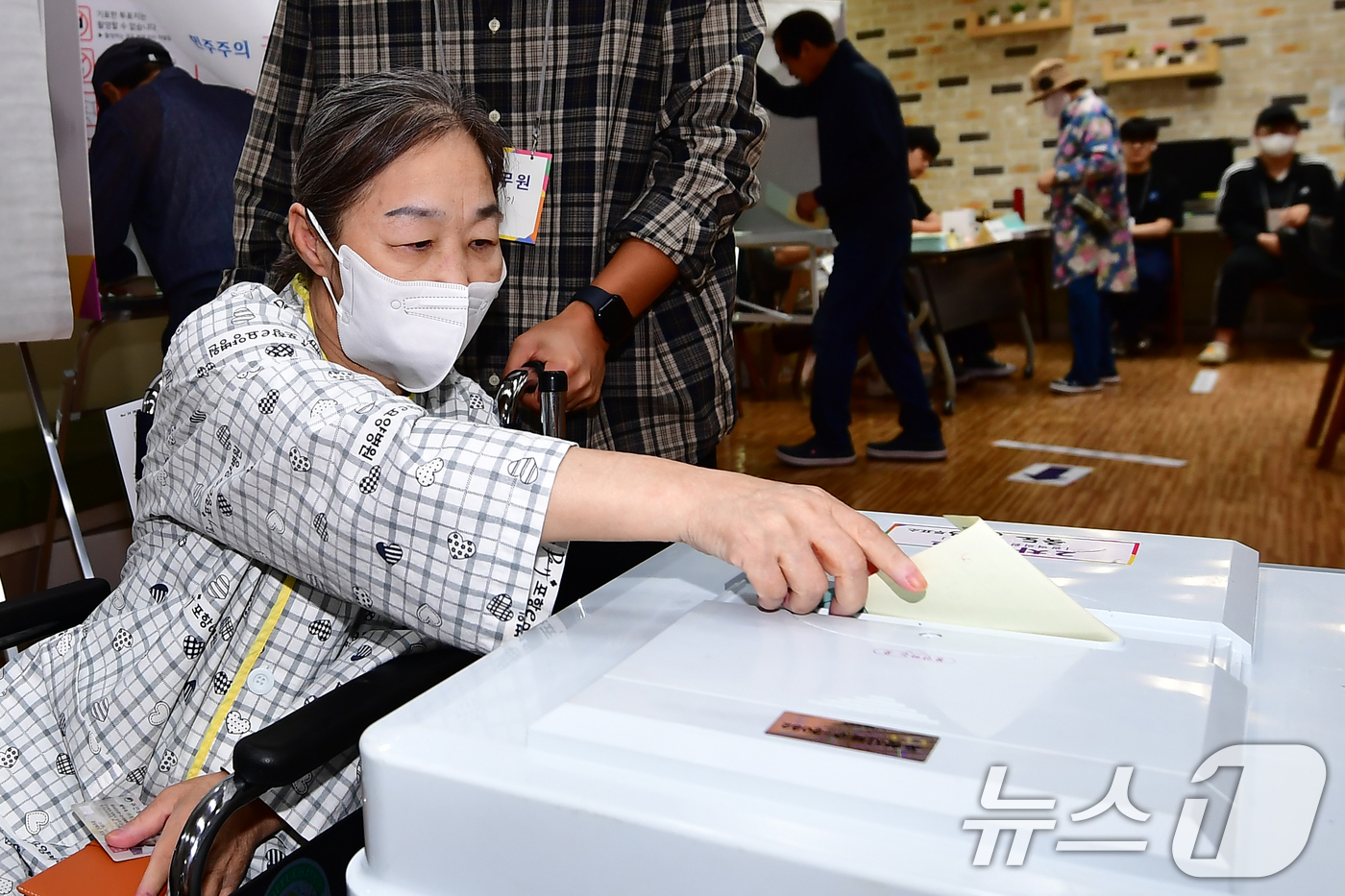 (포항=뉴스1) 최창호 기자 = 제9회 전국동시지방선거 본 투표일인 3일 오전 경북 포항시 북구 죽도동 포항고용복지플러스센터에 마련된 투표소에서 휠체어를 탄 유권자가 선거사무원의 …