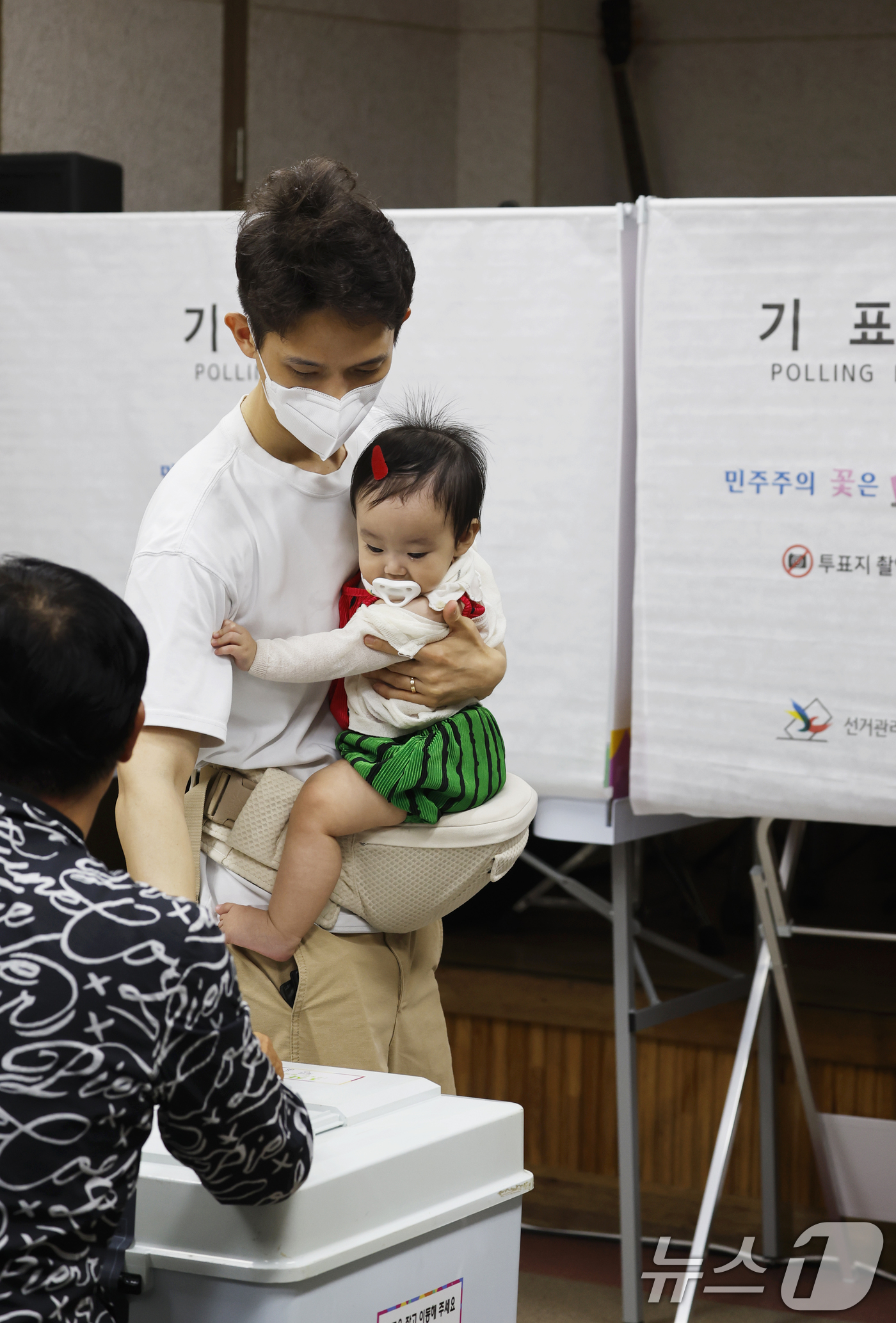 (광주=뉴스1) 김태성 기자 = 제9회 전국동시지방선거일인 3일 광주 광산구 평동 제1투표소인 평동드림센터에서 한 시민이 아이와 함께 투표를 하고 있다.  2026.6.3/뉴스1