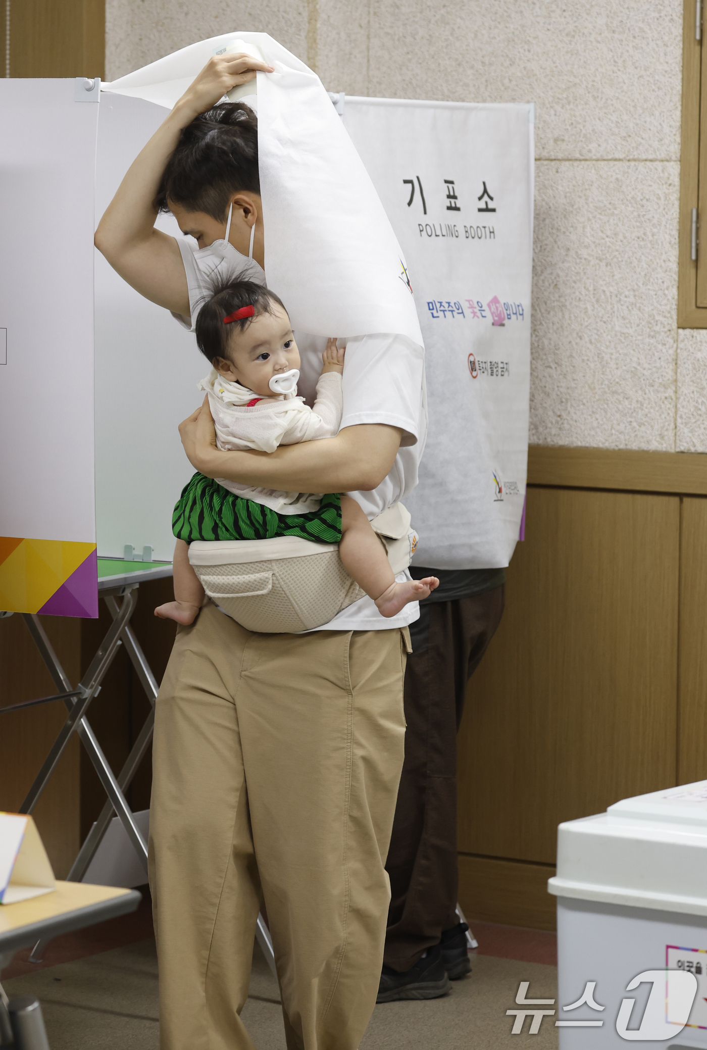 (광주=뉴스1) 김태성 기자 = 제9회 전국동시지방선거일인 3일 광주 광산구 평동 제1투표소인 평동드림센터에서 한 시민이 아이와 함께 투표를 하고 있다.  2026.6.3/뉴스1