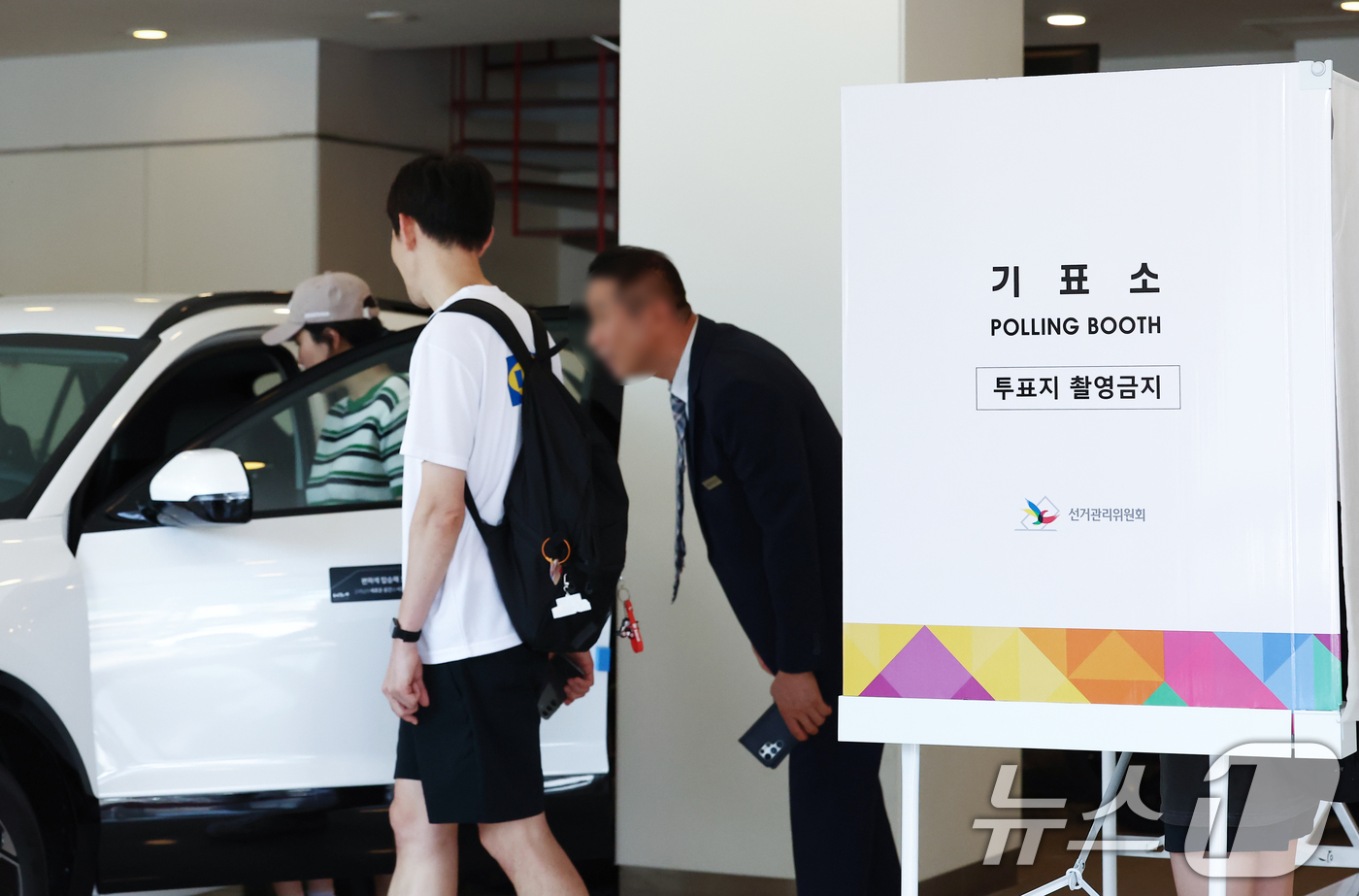 (서울=뉴스1) 김민지 기자 = 제9회 전국동시지방선거 투표일인 3일 오전 서울 광진구 기아자동차 대공원대리점 전시장에 마련된 능동제3투표소에서 시민들이 투표를 마치고 차량을 시승 …
