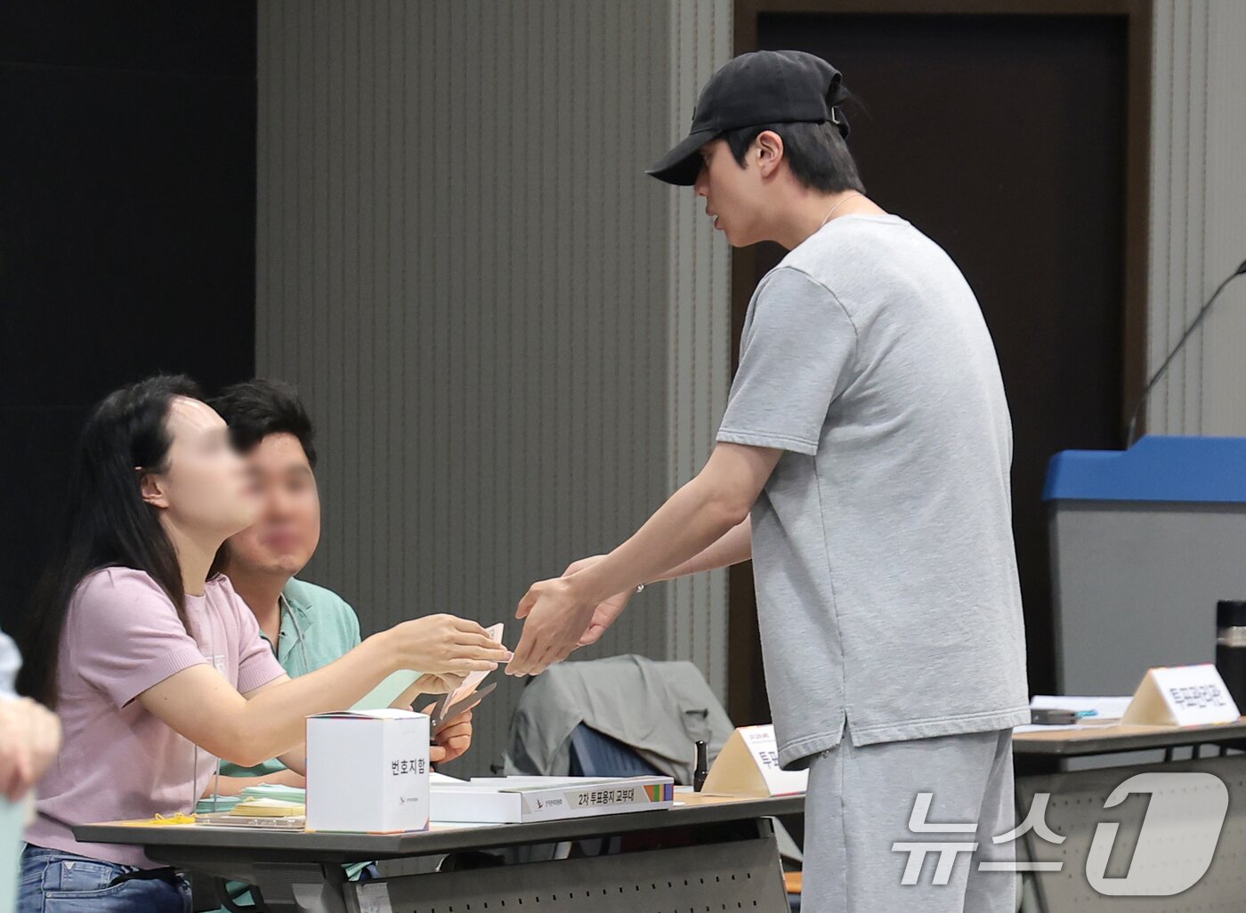 본문 이미지 - 방탄소년단(BTS) 진이 제9회 전국동시지방선거 및 국회의원 재·보궐선거일인 3일 서울 용산구 중부기술교육원에 마련된 한남동 제3투표소에서 투표 용지를 받고 있다. ⓒ 뉴스1 권현진 기자