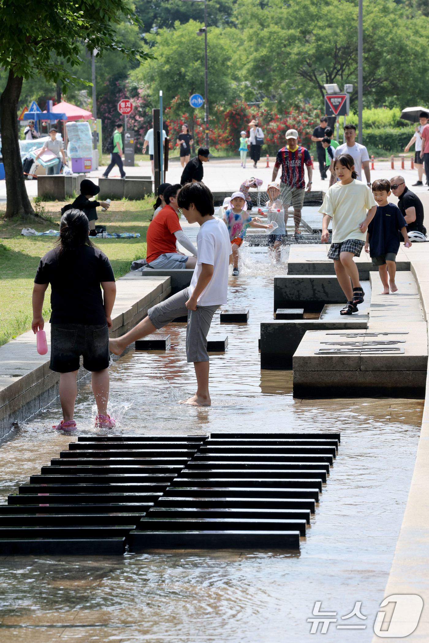 (서울=뉴스1) 이광호 기자 = 6.3지방선거 투표일인 3일 낮 기온이 30도를 넘으며 무더운 날씨를 보이자 서울 영등포구 여의도한강공원을 찾은 시민들이 물놀이를 하며 더위를 식히 …