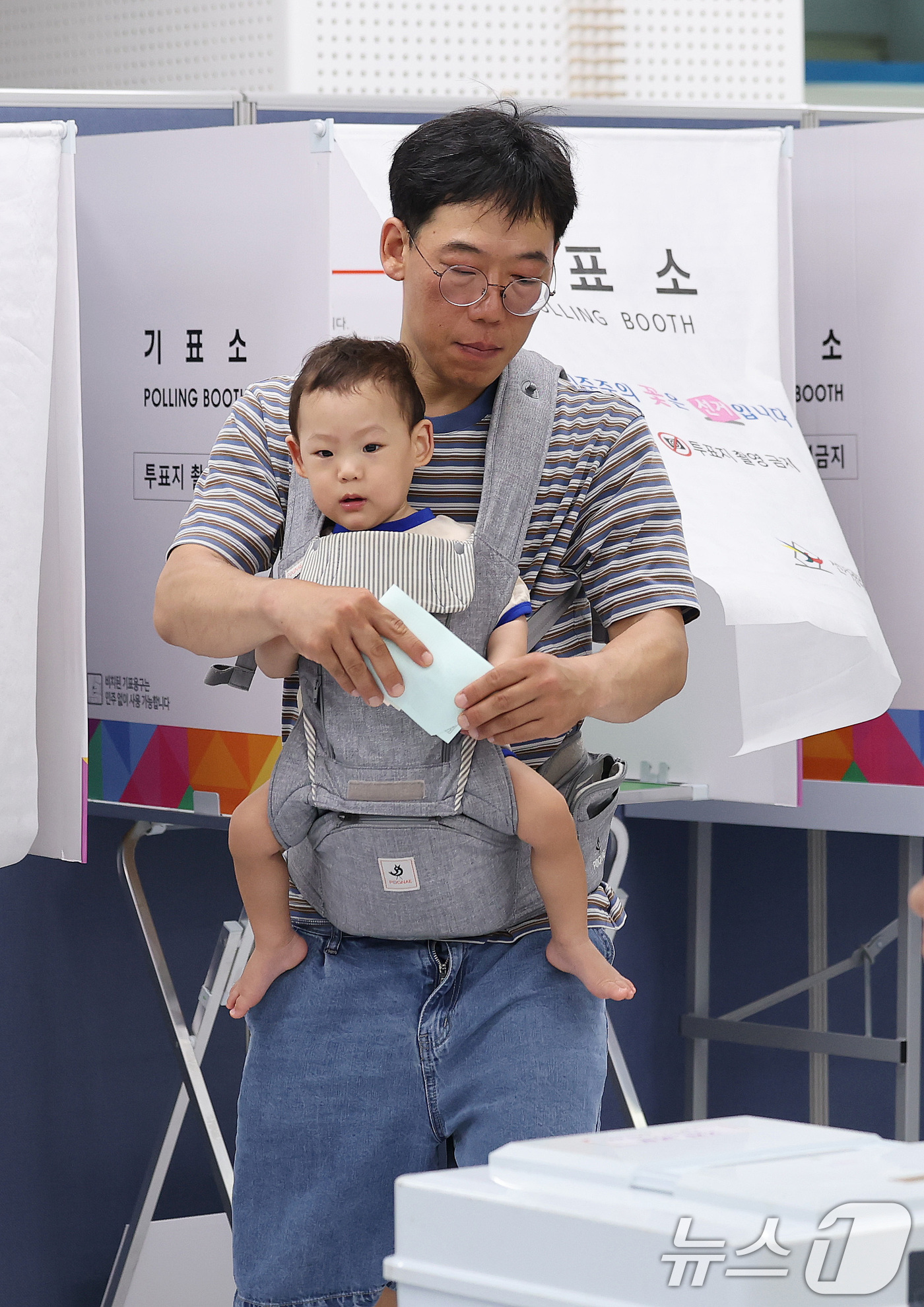 (서울=뉴스1) 박지혜 기자 = 제9회 전국동시지방선거일인 3일 서울 강남구 강남구청에 마련된 삼성2동 제5투표소에서 한 시민이 아기를 아기띠에 안은 채 소중한 한 표를 행사하고 …