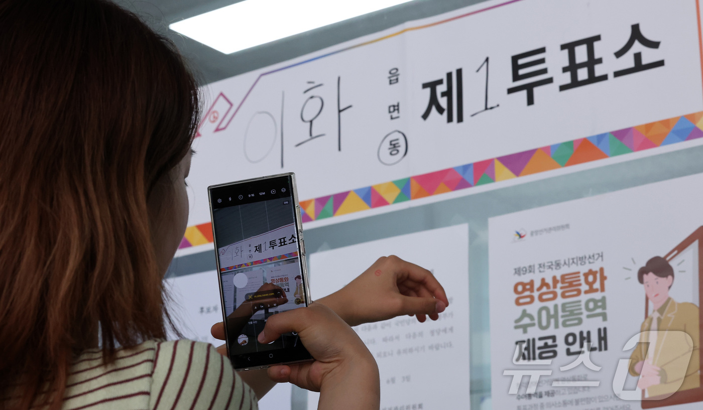 (서울=뉴스1) 김성진 기자 = 제9회 전국동시지방선거일인 3일 서울 종로구 상명대학교 예술디자인센터에 마련된 이화동 제1투표소에서 한 유권자가 인증샷을 남기고 있다. 2026.6 …