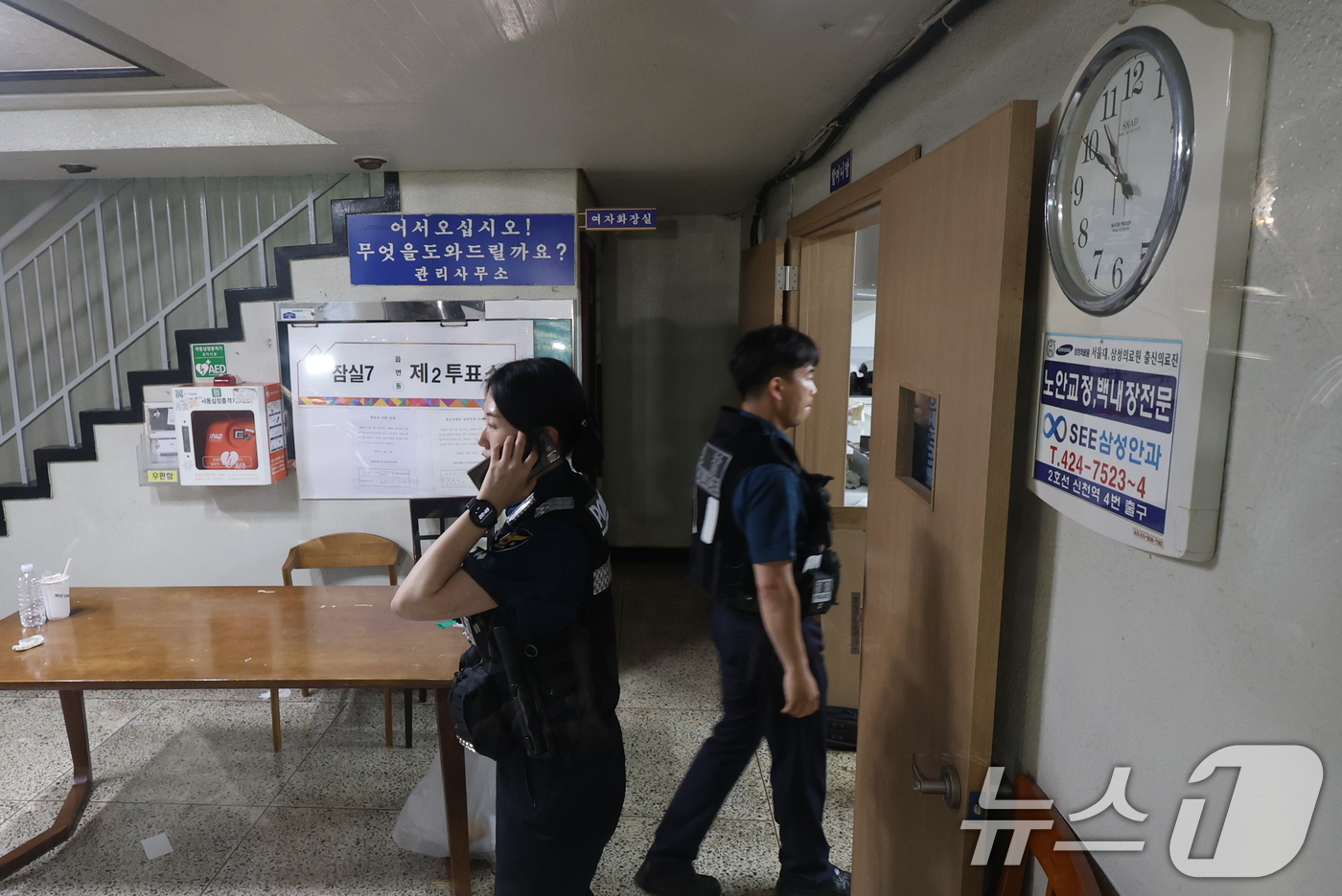 (서울=뉴스1) 박지혜 기자 = 6·3 지방선거 본투표일인 3일 투표용지 부족으로 투표시간이 오후 10시까지 연장된 서울 송파구 잠실7동 제2투표소에 경찰들이 들어가고 있다. 20 …