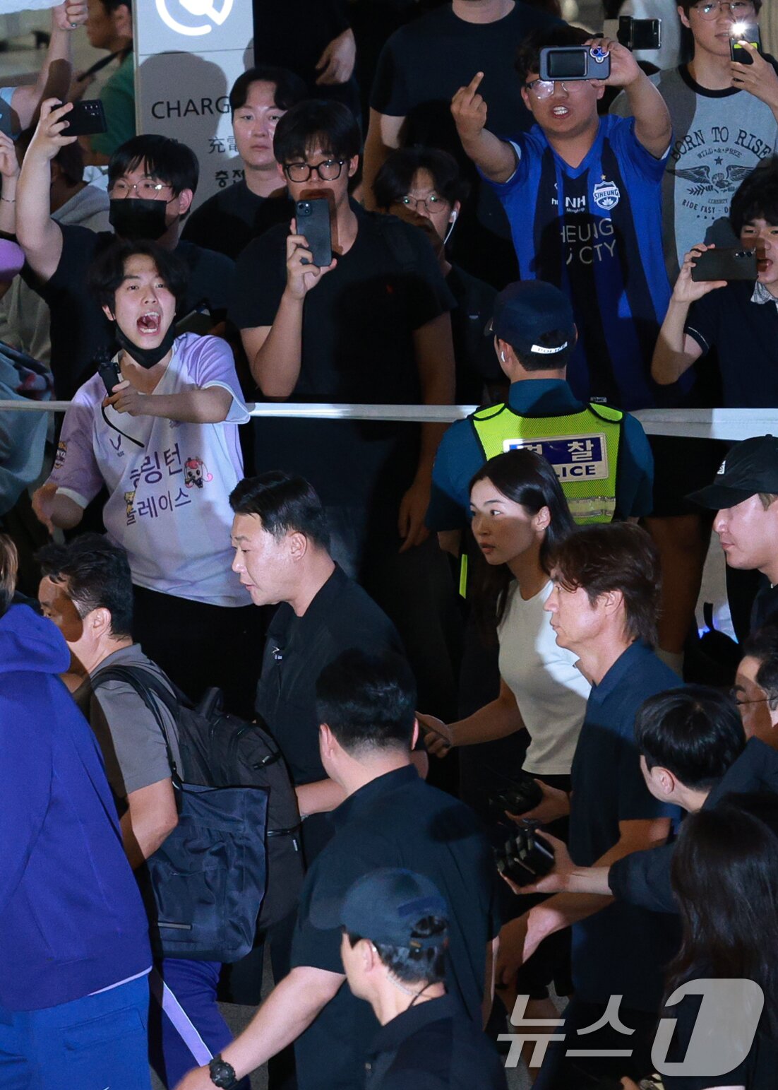 본문 이미지 - 2026 북중미 월드컵 32강 진출 실패의 책임을 지고 사퇴 의사를 밝힌 홍명보 축구대표팀 감독이 30일 새벽 인천국제공항 2터미널에 도착, 축구팬들 아유를 받으며 이동하고 있다. (공동취재) 2026.6.30 ⓒ 뉴스1 안은나 기자