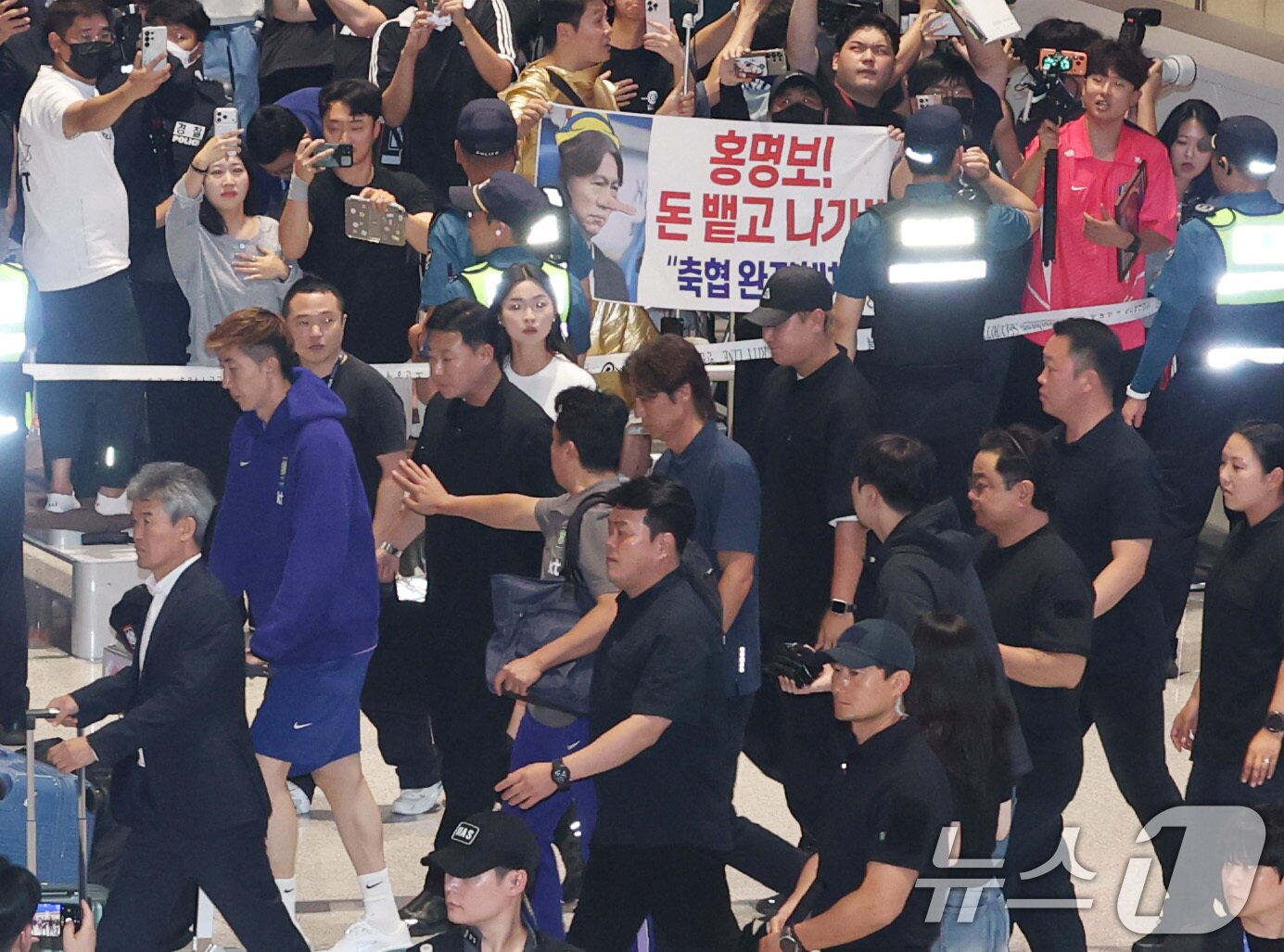 본문 이미지 - 2026 북중미 월드컵 32강 진출 실패의 책임을 지고 사퇴 의사를 밝힌 홍명보 축구대표팀 감독이 30일 새벽 인천국제공항 2터미널에 도착, 축구팬들 아유를 받으며 이동하고 있다. (공동취재) 2026.6.30 ⓒ 뉴스1 안은나 기자
