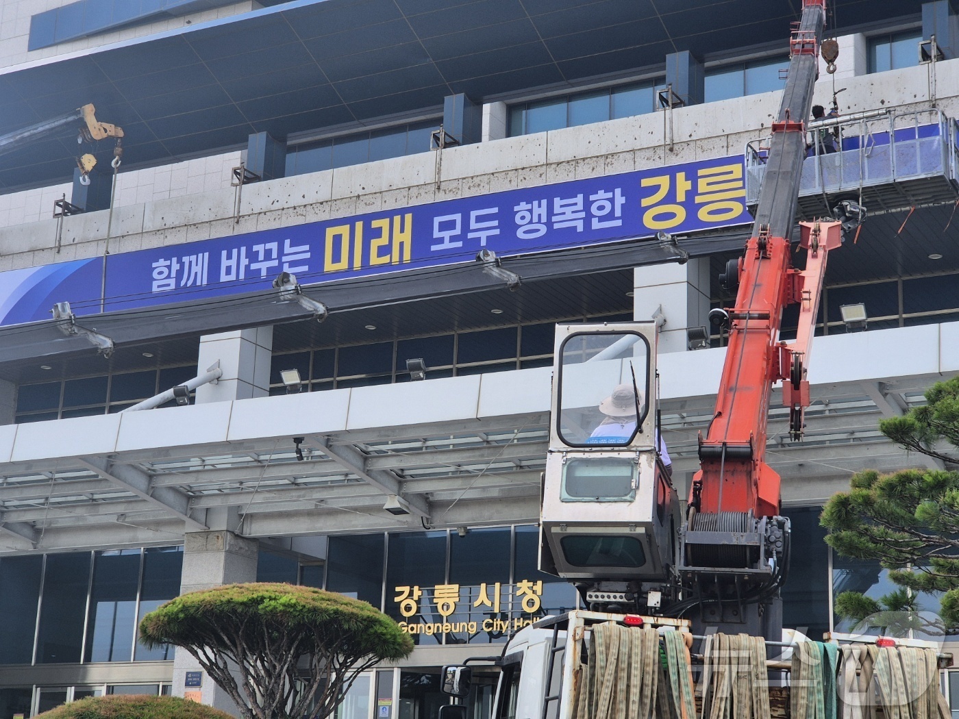 (강릉=뉴스1) 윤왕근 기자 = 민선 9기 출범을 하루 앞둔 30일 강원 강릉시청 청사 외벽에 새 시정구호인 \'함께 바꾸는 미래, 모두 행복한 강릉\' 현판이 설치되고 있다. 2 …