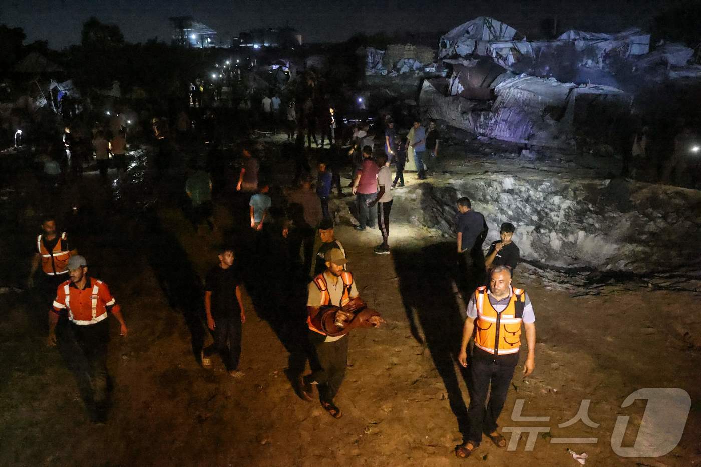 (칸유니스 AFP=뉴스1) 한수민 수습기자 = 29일(현지시간) 팔레스타인 가자지구 남부 칸 유니스에서 이스라엘이 공습 경보를 발령한 현장에 팔레스타인 응급 구조대원들이 서 있다. …