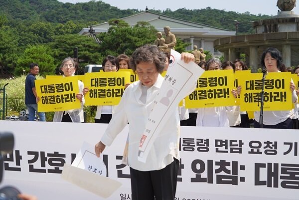 본문 이미지 - 신경림 대한간호협회 회장이 30일 서울 청와대 분수대 앞에서 열린 기자회견에서 대형 간호사 면허증 모형을 찢는 퍼포먼스를 하고 있다. (간협 제공)