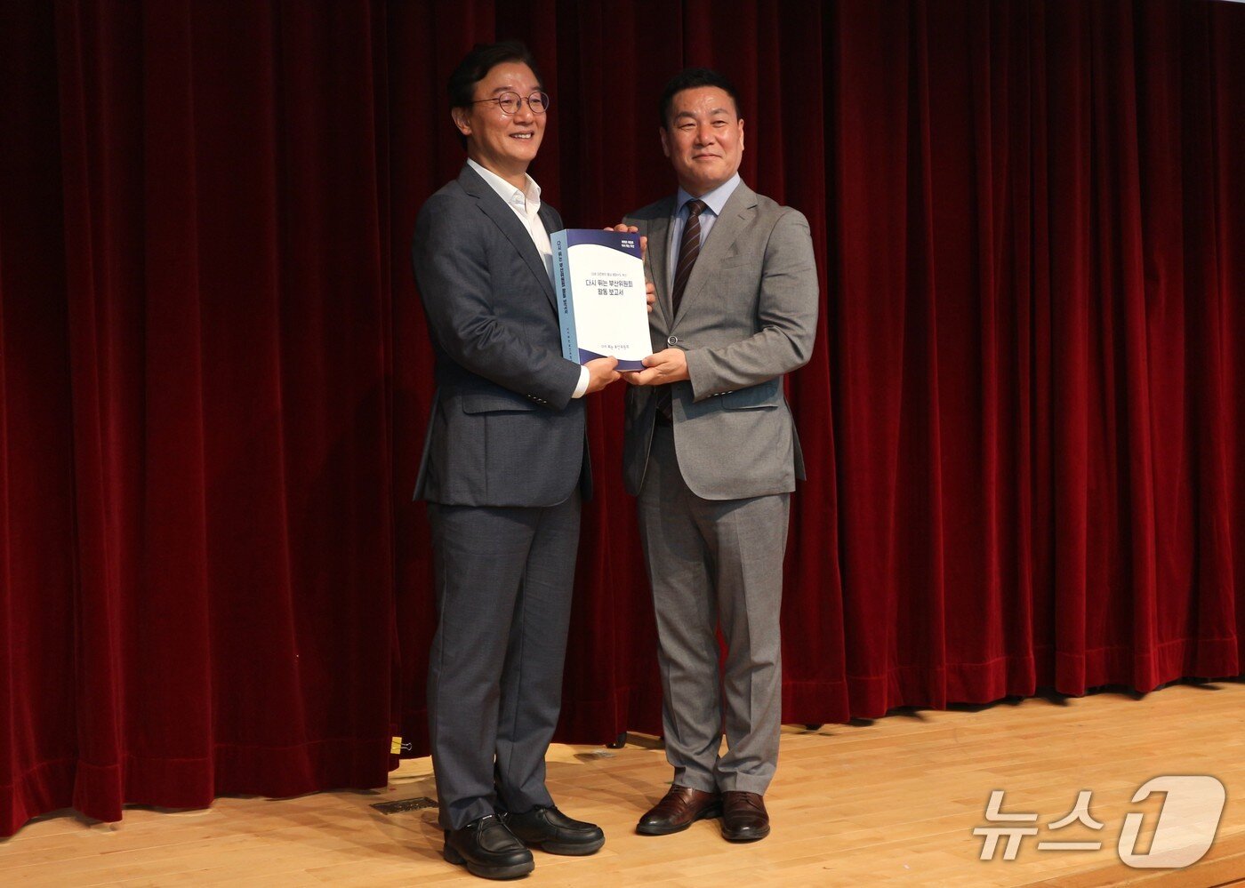 본문 이미지 - 전재수 당선인이 차재권 위원장으로부터 인수위 활동보고서를 전달받고 있다.2026.6.30 ⓒ 뉴스1 이주현 기자