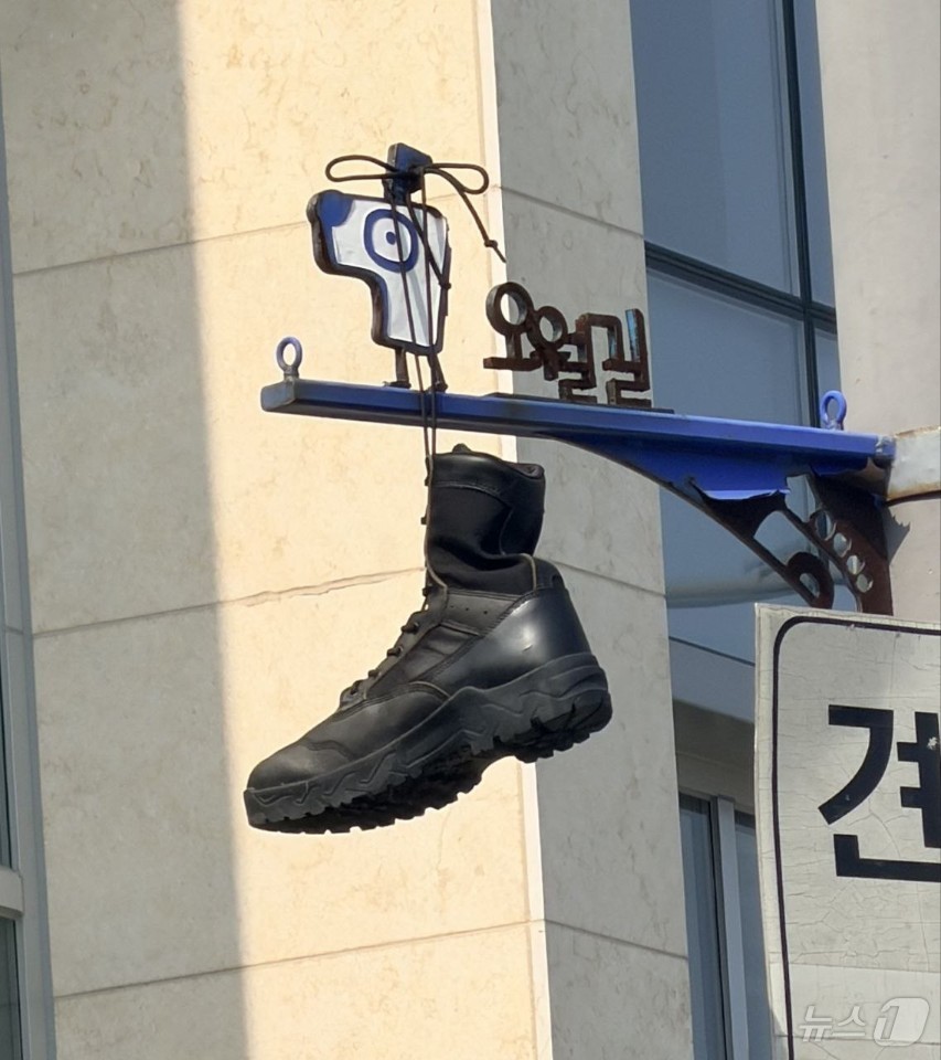 (광주=뉴스1) 전원 기자 = 30일 광주 동구 대인동의 한 교차로에 설치된 오월길을 안내하는 표지판에 군화가 걸려 있다.5.18기념재단과 광주시는 군화를 수거하는 한편 누가, 어 …