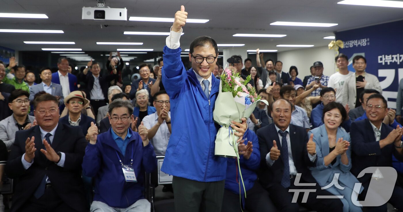 본문 이미지 - 김상욱 더불어민주당 울산시장 후보가 3일 오후 울산 남구에 마련된 자신의 선거캠프에서 당선이 확실시 되자 꽃다발을 들고 환호하고 있다. 2026.6.4 ⓒ 뉴스1 조민주 기자