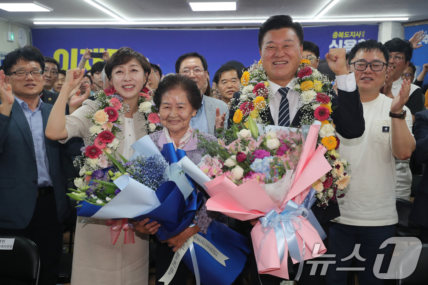 (청주=뉴스1) 김용빈 기자 = 더불어민주당 신용한 충북지사 후보와 어머니, 배우자 이채영 씨가 3일 오후 충북 청주시 흥덕구 선거사무소에서 당선이 유력시되자 꽃목걸이를 걸고 세리 …