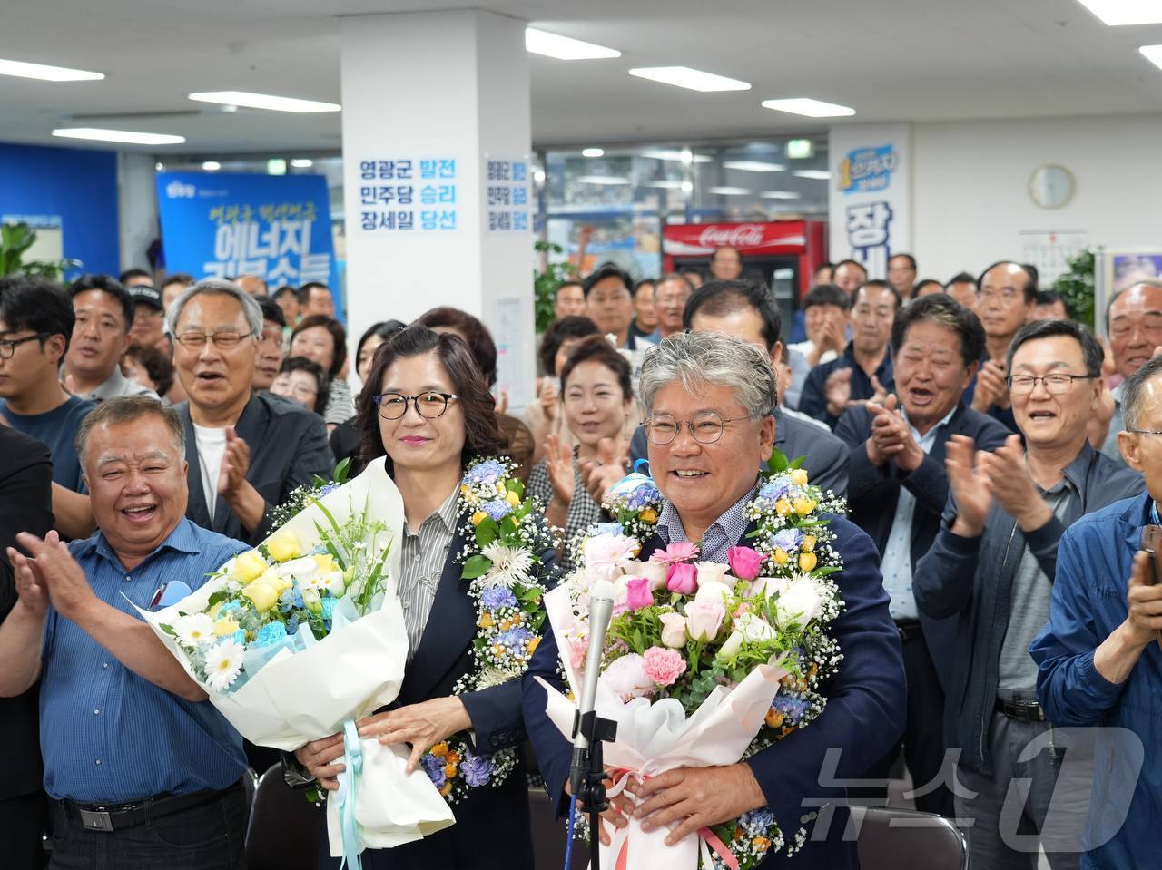 (영광=뉴스1) = 장세일 더불어민주당 영광군수 후보가 3일 전남 영광군 자신의 선거사무소에서 당선이 확실시되자 배우자와 꽃목걸이를 걸고 환호하고 있다. (장세일 캠프 제공. 재배 …
