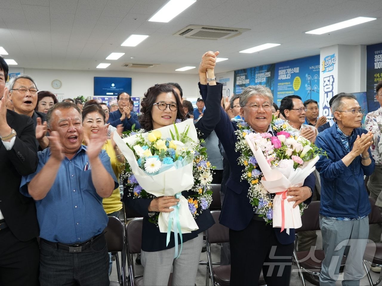(영광=뉴스1) = 장세일 더불어민주당 영광군수 후보가 3일 전남 영광군 자신의 선거사무소에서 당선이 확실시되자 배우자와 꽃목걸이를 걸고 환호하고 있다. (장세일 캠프 제공. 재배 …