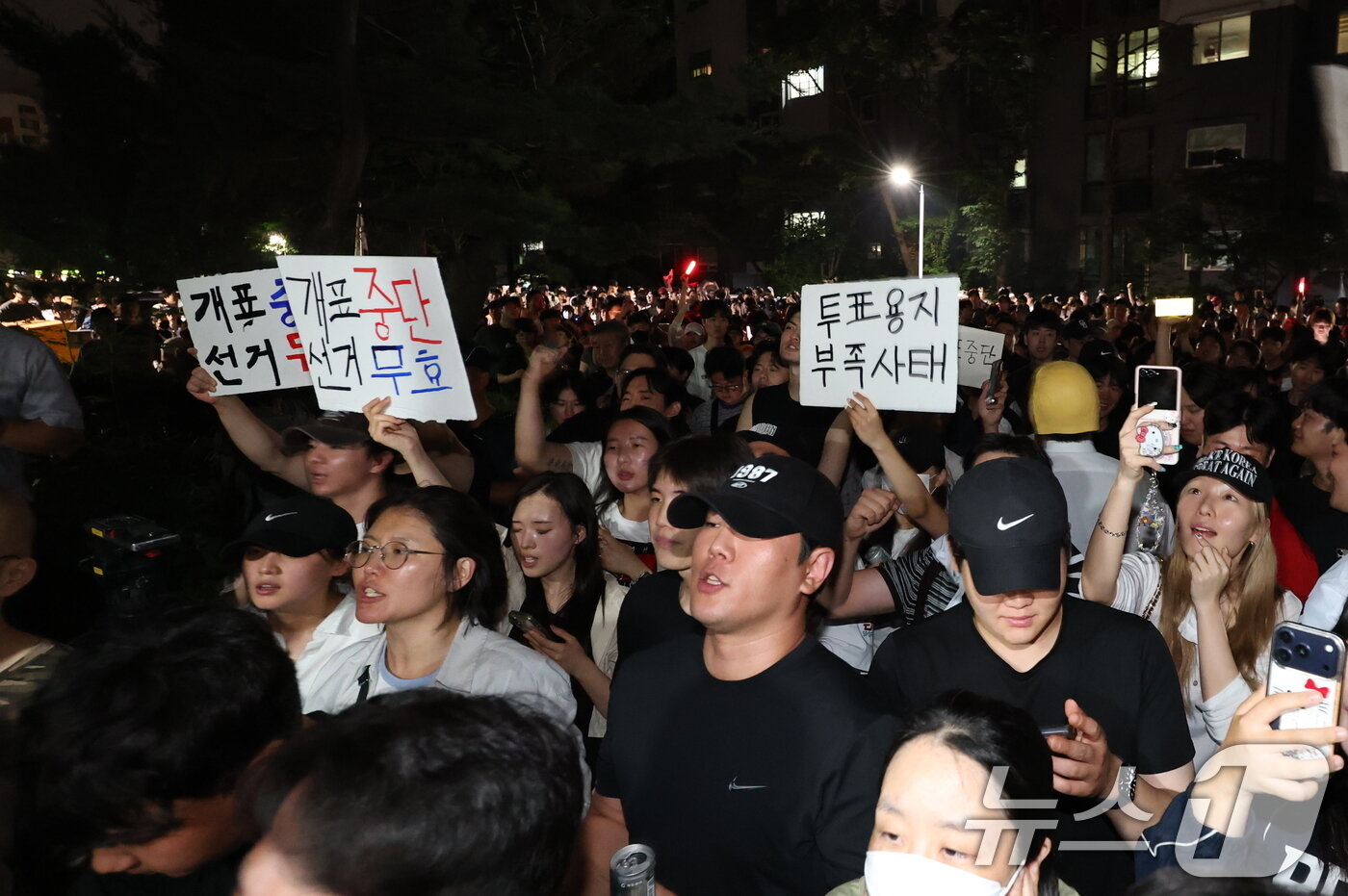 본문 이미지 - 제9회 전국동시지방선거 및 국회의원 재·보궐선거 본투표일에 투표용지 부족으로 투표 시간이 오후 10시까지 연장됐던 서울 송파구 잠실7동 제2투표소 앞에 4일 새벽 투표용지 부족 사태에 항의하는 시민 등이 모여 '개표 중단과 선거무효'를 요구하고 있다. 2026.6.4 ⓒ 뉴스1 박지혜 기자