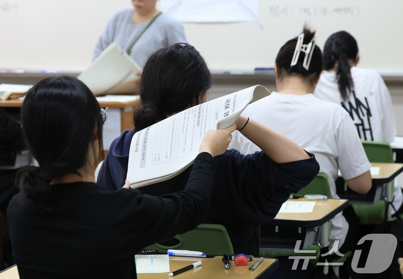 (서울=뉴스1) 사진공동취재단 = 2027학년도 대학수학능력 6월 모의평가일인 4일 오전 서울 마포구 서울여고에서 수험생들이 1교시 국어 영역 시험을 앞두고 시험지를 받고있다. 2 …