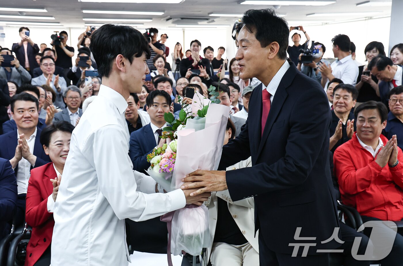 본문 이미지 - 6·3 지방선거에서 당선된 오세훈 국민의힘 서울시장 후보가 4일 서울 종로구 선거사무소에서 꽃다발을 전달 받고 있다. 2026.6.4 ⓒ 뉴스1 김도우 기자