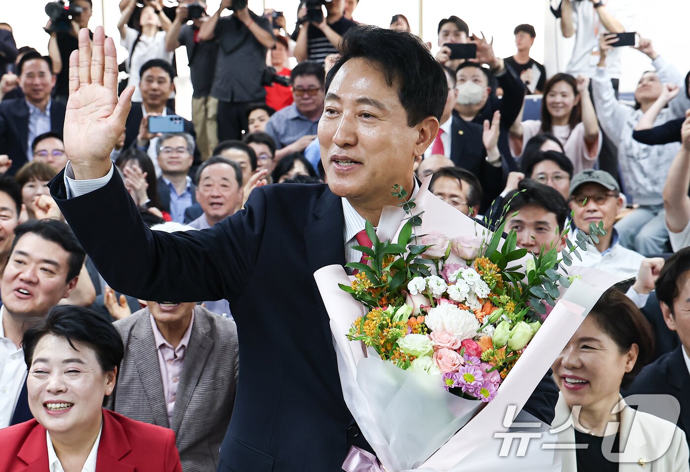 본문 이미지 - 6·3 지방선거에서 당선된 오세훈 국민의힘 서울시장 후보가 4일 서울 종로구 선거사무소에서 꽃다발을 전달 받고 환호 하고 있다. 2026.6.4 ⓒ 뉴스1 김도우 기자