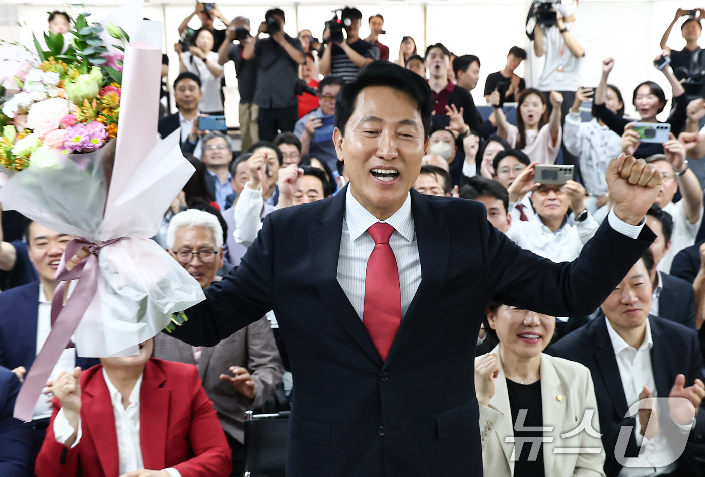 (서울=뉴스1) 김도우 기자 = 6·3 지방선거에서 당선된 오세훈 국민의힘 서울시장 후보가 4일 서울 종로구 선거사무소에서 꽃다발을 전달 받고 환호 하고 있다. 2026.6.4/뉴 …