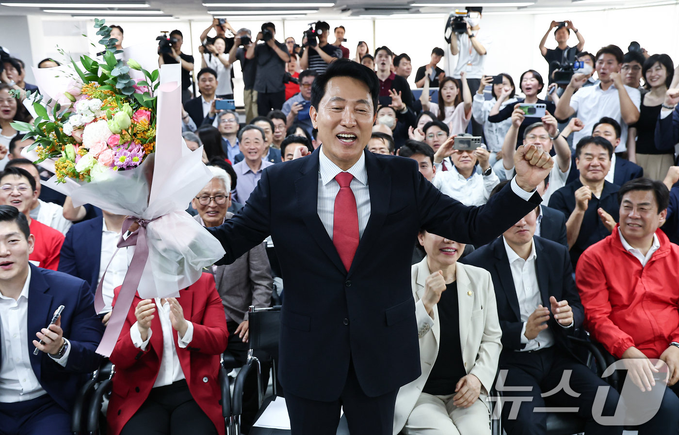 (서울=뉴스1) 김도우 기자 = 6·3 지방선거에서 당선된 오세훈 국민의힘 서울시장 후보가 4일 서울 종로구 선거사무소에서 꽃다발을 전달 받고 환호 하고 있다. 2026.6.4/뉴 …