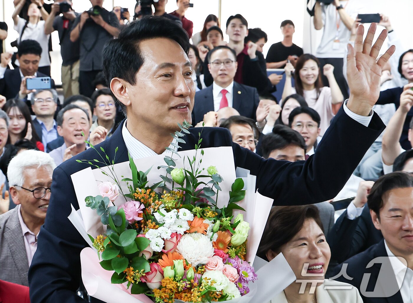본문 이미지 - 6·3 지방선거에서 당선된 오세훈 국민의힘 서울시장 후보가 4일 서울 종로구 선거사무소에서 꽃다발을 전달 받고 환호 하고 있다. 2026.6.4 ⓒ 뉴스1 김도우 기자
