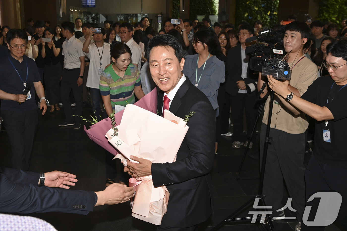(서울=뉴스1) 이호윤 기자 = 오세훈 서울시장 당선인이 4일 오전 서울시청 로비에서 직원들이 준비해 준 꽃다발을 받고 기뻐하고 있다. (공동취재) 2026.6.4/뉴스1