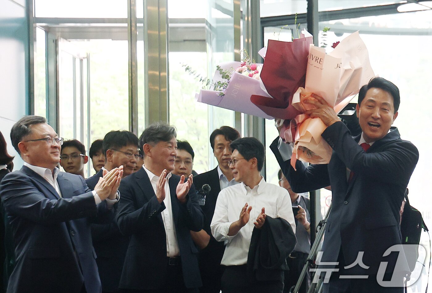 본문 이미지 - 오세훈 서울시장 당선인이 4일 오전 서울시청 로비에서 직원들이 준비해 준 꽃다발을 받고 기뻐하고 있다. (공동취재) 2026.6.4 ⓒ 뉴스1 이호윤 기자