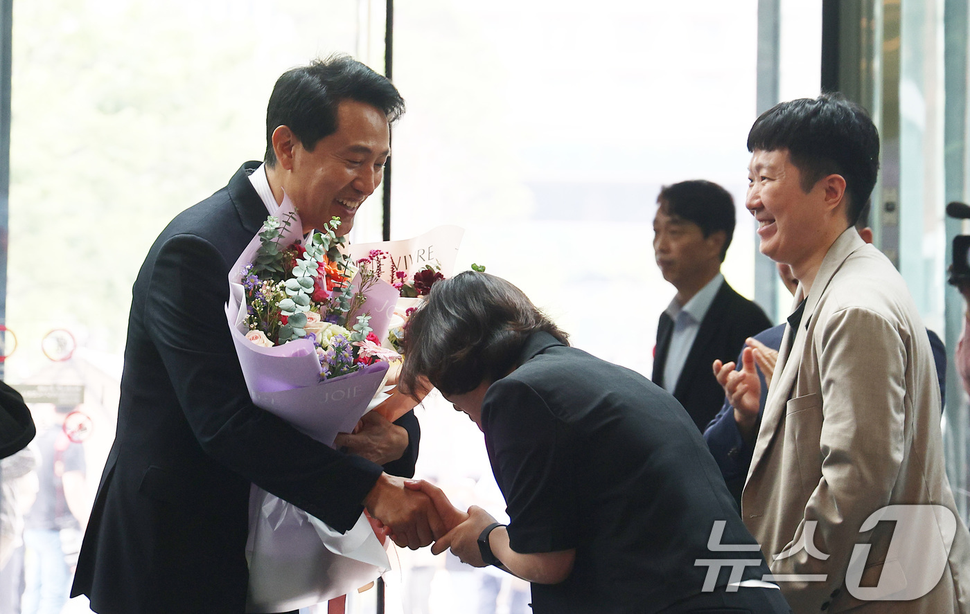 (서울=뉴스1) 이호윤 기자 = 오세훈 서울시장 당선인이 4일 오전 서울시청 로비에서 직원들로부터 꽃다발을 받은 후 인사하고 있다. (공동취재) 2026.6.4/뉴스1