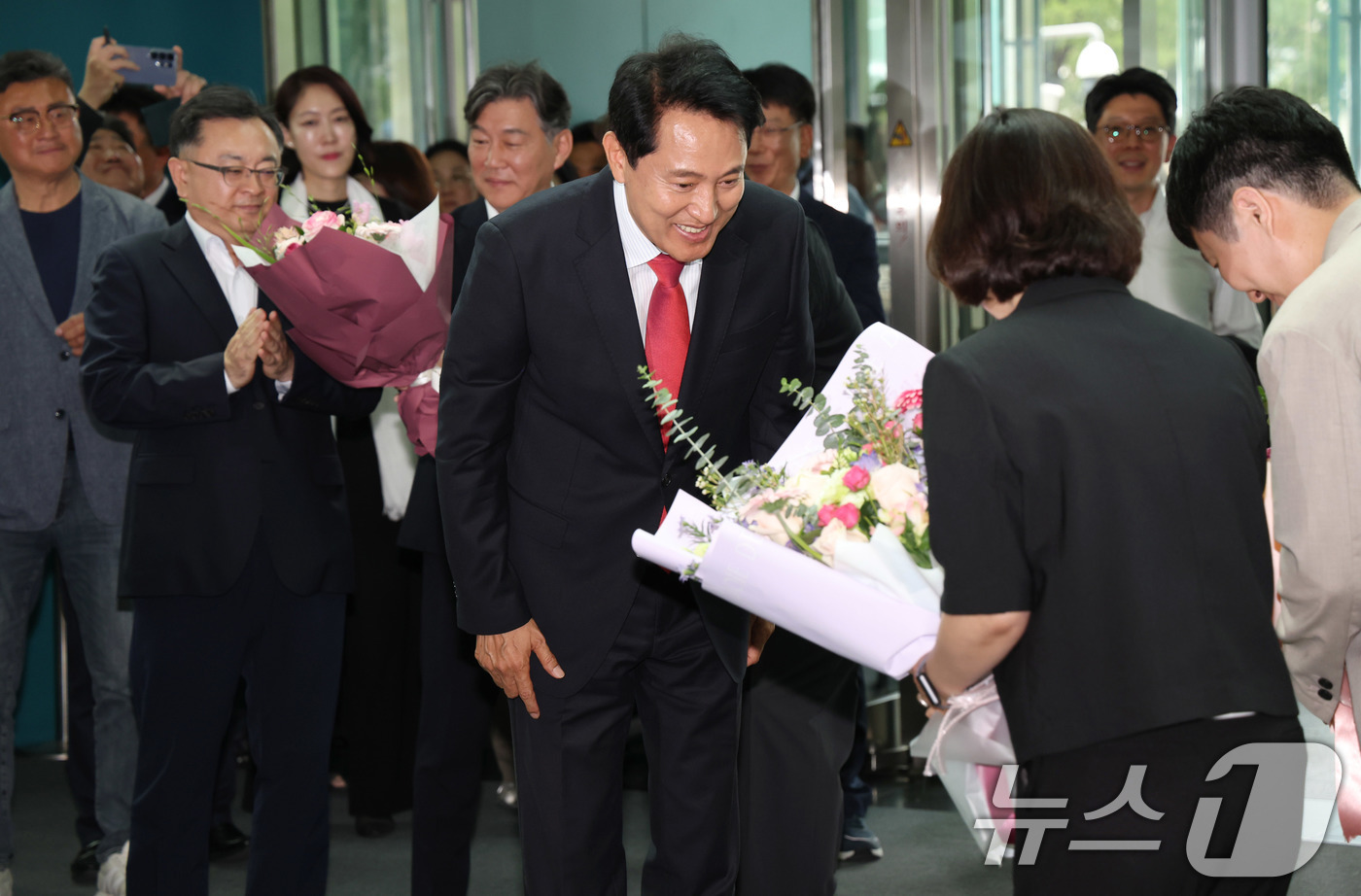 (서울=뉴스1) 이호윤 기자 = 오세훈 서울시장 당선인이 4일 오전 서울시청 로비에서 직원들이 준비해 준 꽃다발을 받고 있다. (공동취재) 2026.6.4/뉴스1