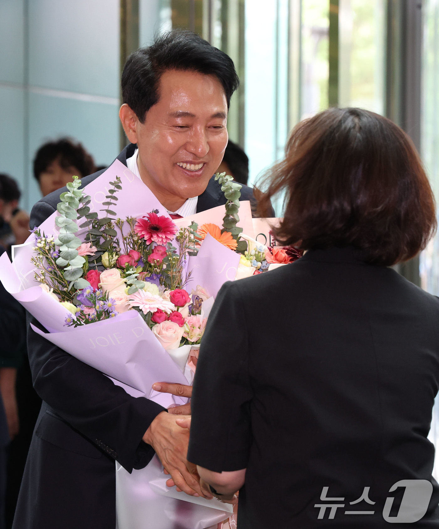 (서울=뉴스1) 이호윤 기자 = 오세훈 서울시장 당선인이 4일 오전 서울시청 로비에서 직원들이 준비해 준 꽃다발을 받고 기뻐하고 있다. (공동취재) 2026.6.4/뉴스1