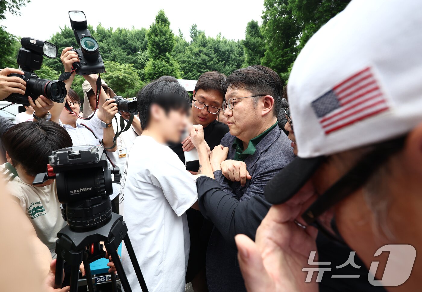본문 이미지 - 4일 오전 제9회 전국동시지방선거 및 국회의원 재·보궐선거 투표함 이송이 지연되고 있는 서울 송파구 잠실7동 제2투표소에서 김범진 서울시선관위 사무처장이 시위대의 반발을 받고 있다. 2026.6.4 ⓒ 뉴스1 김민지 기자