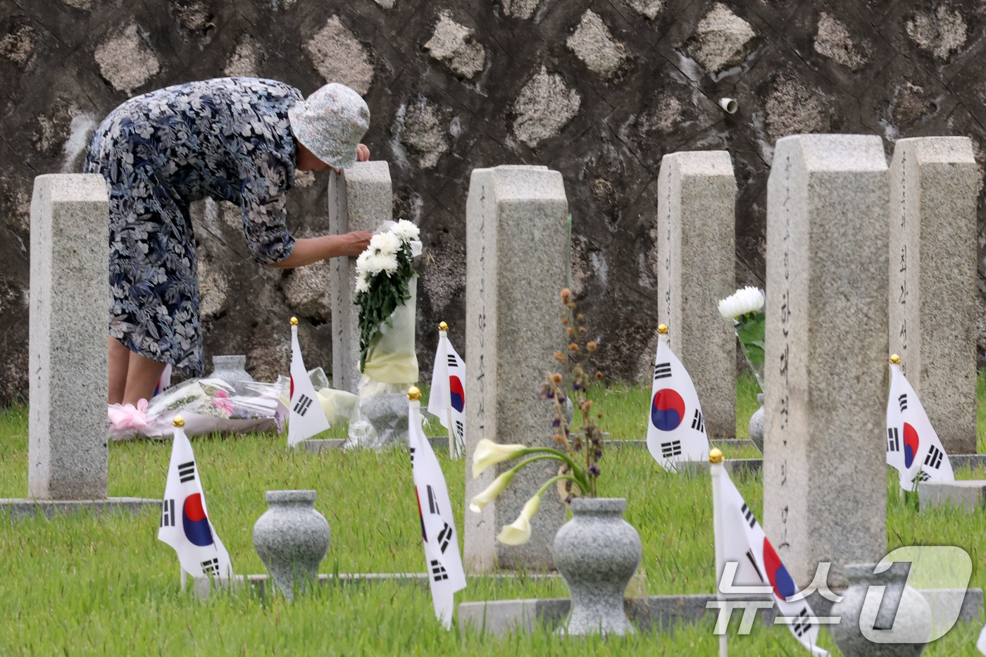 (서울=뉴스1) 이광호 기자 = 현충일을 이틀 앞둔 4일 서울 동작구 국립서울현충원을 찾은 참배객이 묘비를 닦고 있다.   2026.6.4/뉴스1