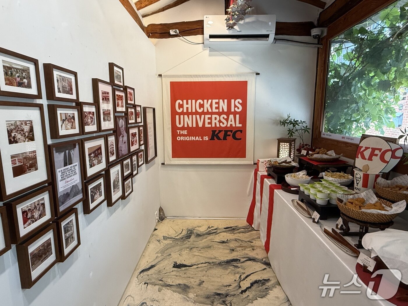 본문 이미지 - KFC 팝업 스토어 '켄터키 할아버지의 바삭한 집들이' 내 '커넬의 사랑방' 모습. KFC의 역사를 담은 사진과 무제한 치킨 바가 마련돼 있다. 2026.6.4 ⓒ 뉴스1 황두현 기자
