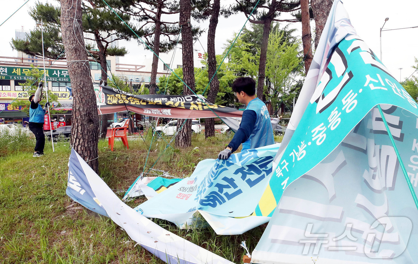 (광주=뉴스1) 박지현 기자 = 6·3 전국동시지방선거 다음날인 4일 광주 북구청 광고물관리팀 직원들이 광주역 앞 보행섬에 설치된 선거 관련 현수막을 철거하고 있다. (광주 북구 …