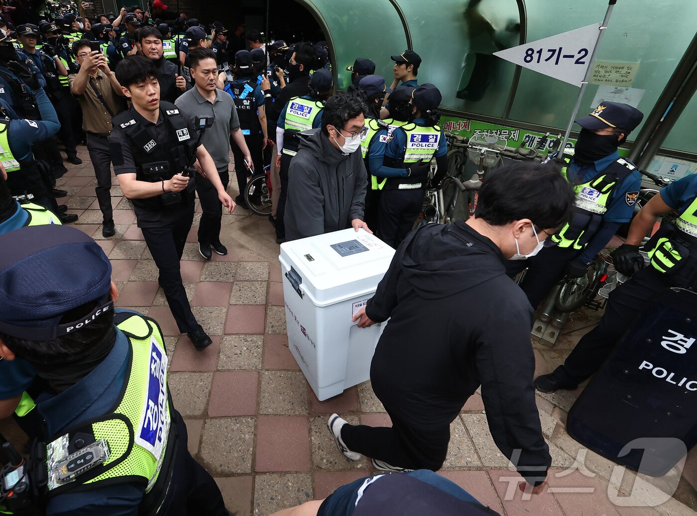 본문 이미지 - 5일 '투표용지 부족' 사태가 발생한 서울 송파구 잠실7동 제2투표소 앞에서 서울시선관위 관계자들이 투표함을 이송하고 있다. 2026.6.5 ⓒ 뉴스1 김도우 기자
