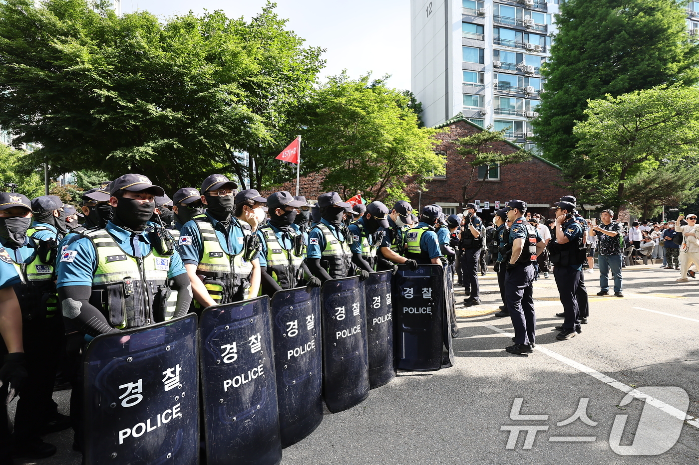 (서울=뉴스1) 김도우 기자 = 5일 '투표용지 부족' 사태가 발생한 서울 송파구 잠실7동 제2투표소 앞에서 경찰들이 투표함 반출을 막는 시위대와 대치하고 있다. 2026.6.5/ …