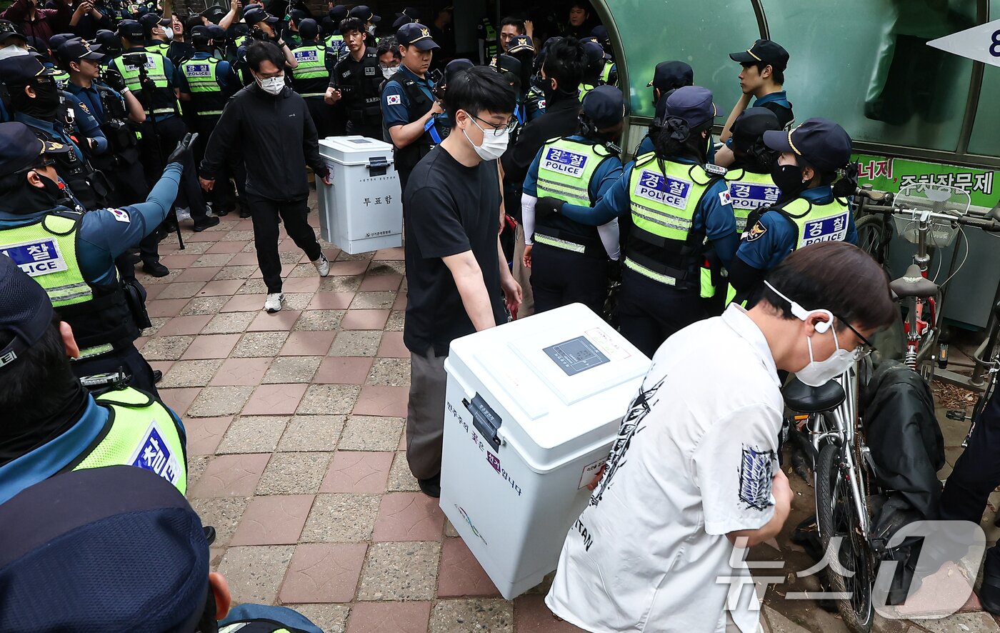 본문 이미지 - 5일 '투표용지 부족' 사태가 발생한 서울 송파구 잠실7동 제2투표소 앞에서 서울시선관위 관계자들이 투표함을 이송하고 있다. 2026.6.5 ⓒ 뉴스1 김도우 기자