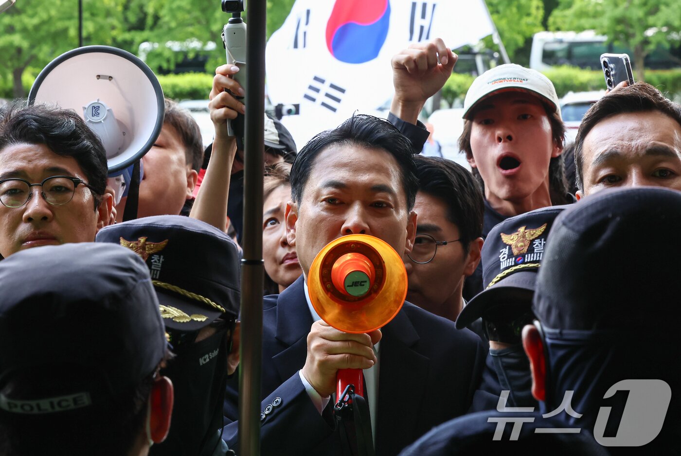 본문 이미지 - 장동혁 국민의힘 대표가 5일 서울 송파구 잠실7동 제2투표소에서 이송된 투표함 개표소인 올림픽공원 핸드볼경기장에 도착해 확성기를 이용해 발언하고 있다. 2026.6.5 ⓒ 뉴스1 김도우 기자