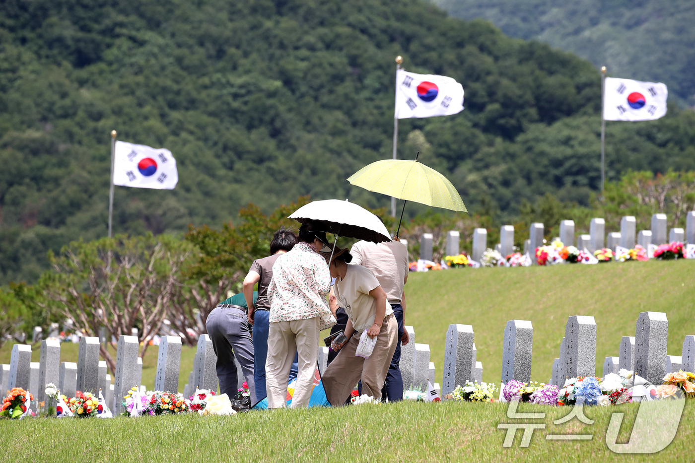 (영천=뉴스1) 공정식 기자 = 현충일을 하루 앞둔 5일 경북 영천시 고경면 국립영천호국원을 찾은 시민들이 양산으로 뙤약볕을 가린 채 참배하고 있다. 2026.6.5/뉴스1