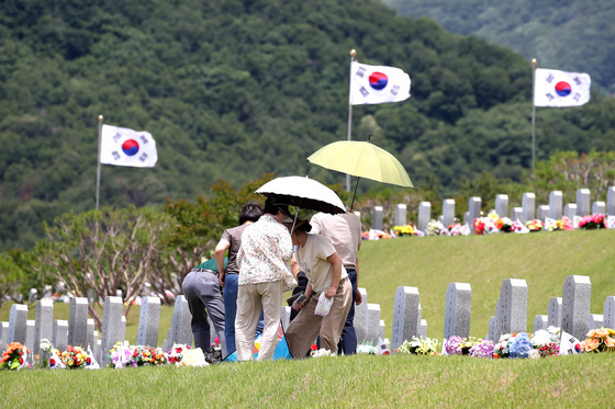 양산으로 뙤약볕 가리고 참배