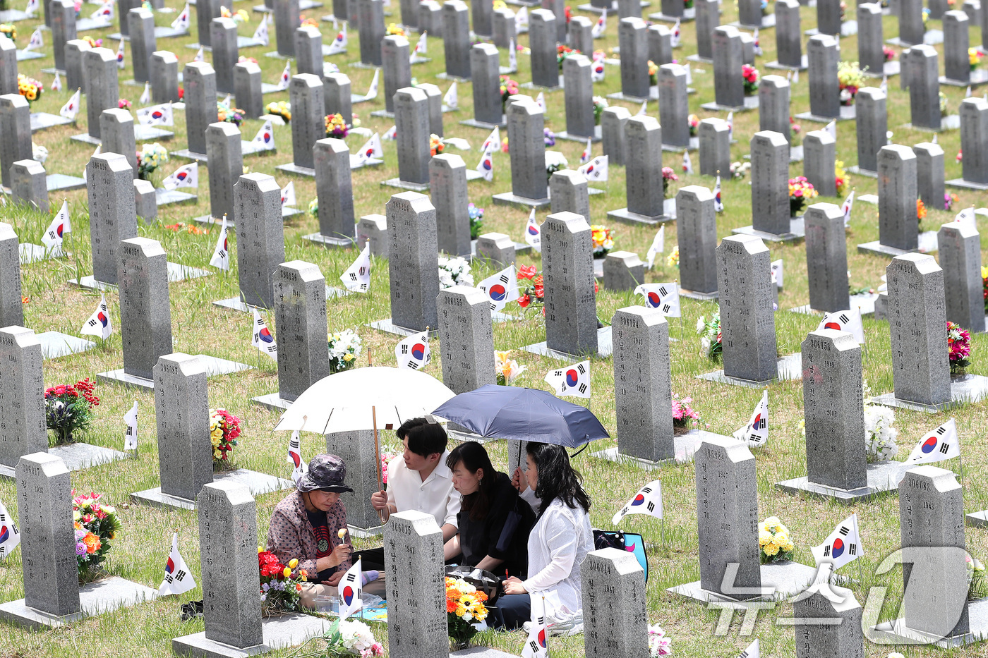 (영천=뉴스1) 공정식 기자 = 현충일을 하루 앞둔 5일 경북 영천시 고경면 국립영천호국원을 찾은 시민들이 양산으로 뙤약볕을 가린 채 참배하고 있다. 2026.6.5/뉴스1