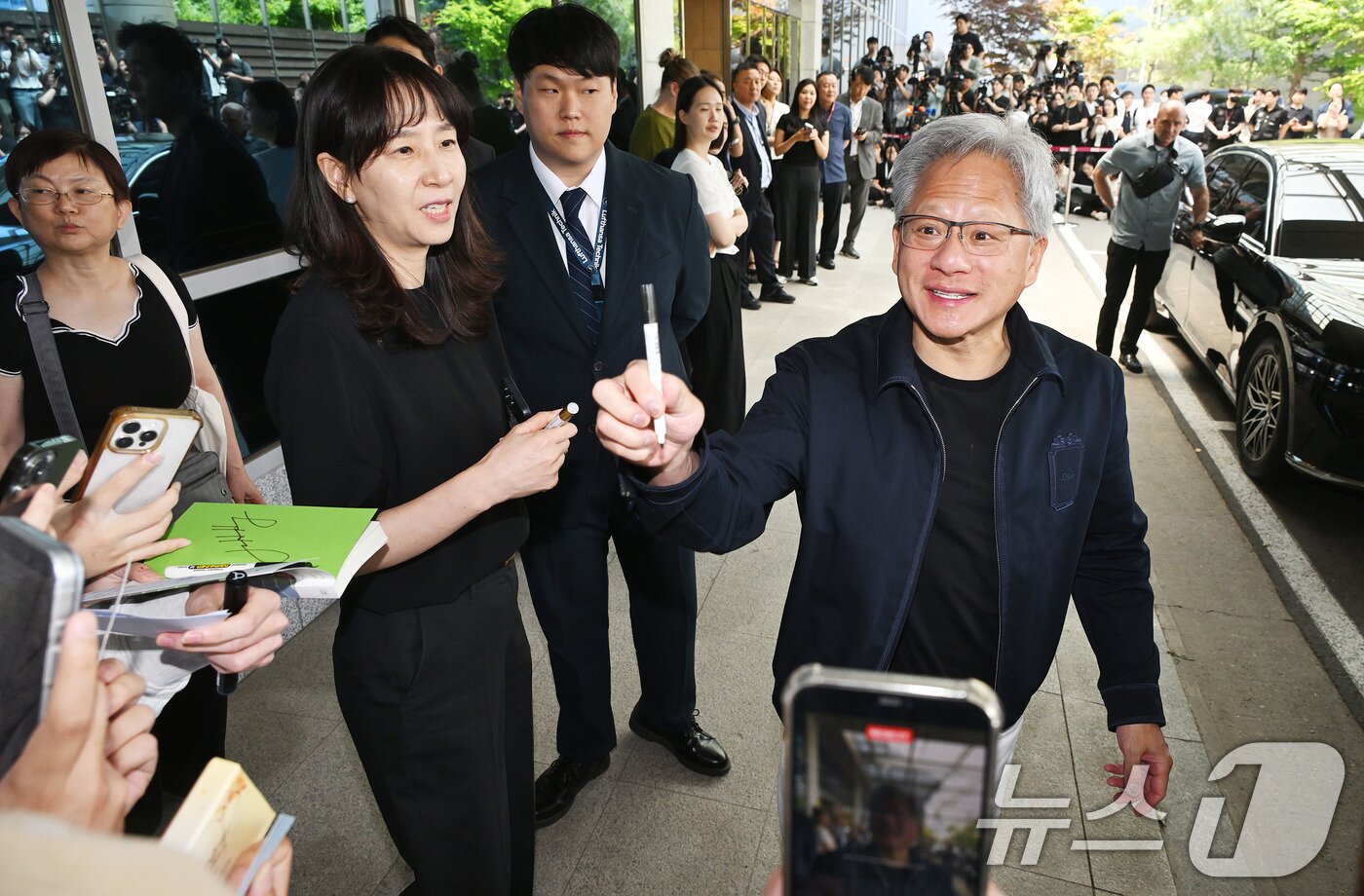 본문 이미지 - 젠슨 황 엔비디아 최고경영자(CEO)가 5일 서울 강서구 서울김포비즈니스항공센터(SGBAC)를 통해 입국해 시민들의 사인 요청에 응하고 있다. (공동취재) 2026.6.5 ⓒ 뉴스1 박지혜 기자