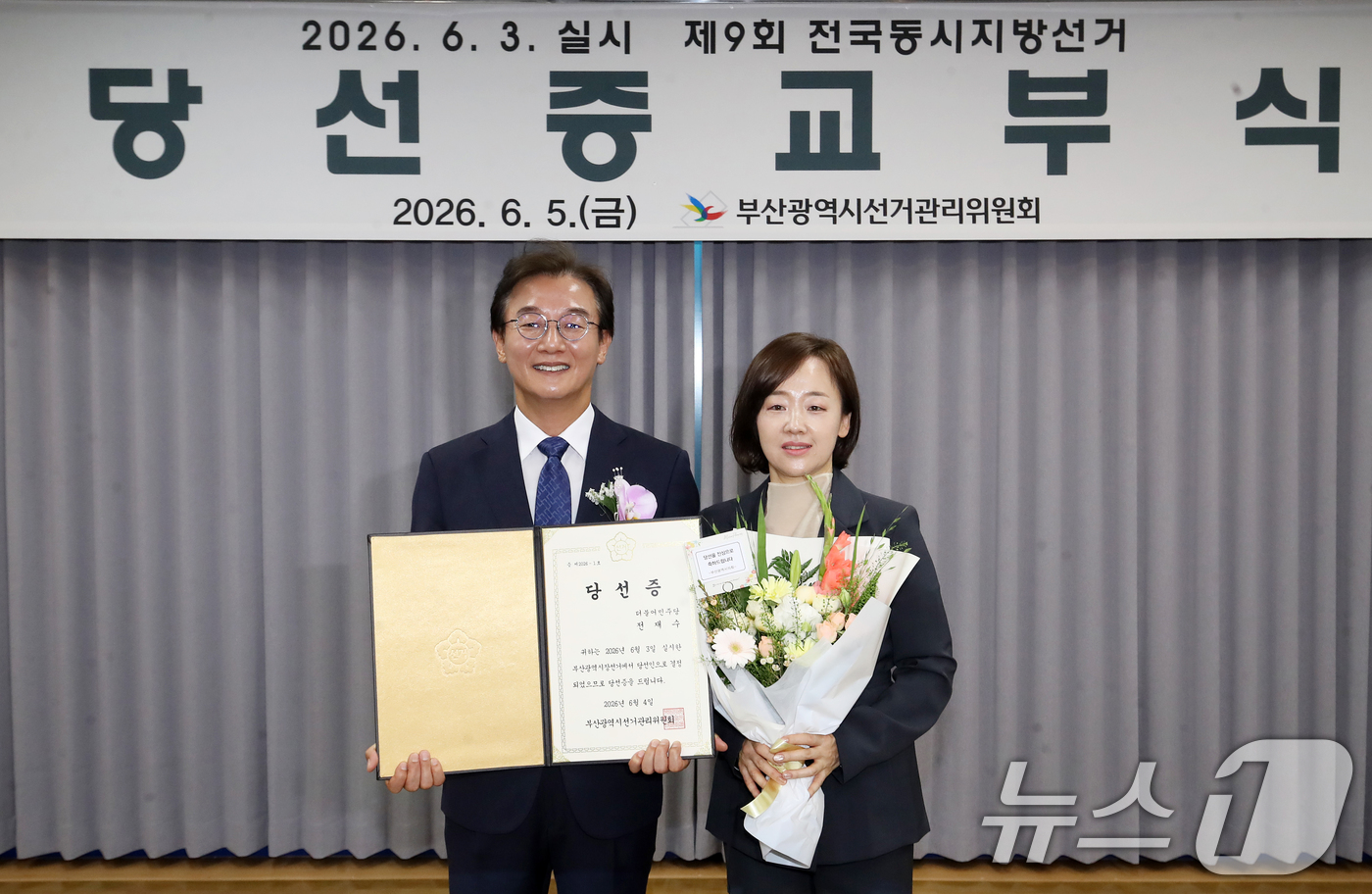 (부산=뉴스1) 윤일지 기자 = 전재수 부산시장 당선인이 5일 오후 부산 연제구 부산시선거관리위원회에서 열린 제9회 전국동시지방선거 당선증 교부식에서 당선증을 교부받은 뒤 배우자 …