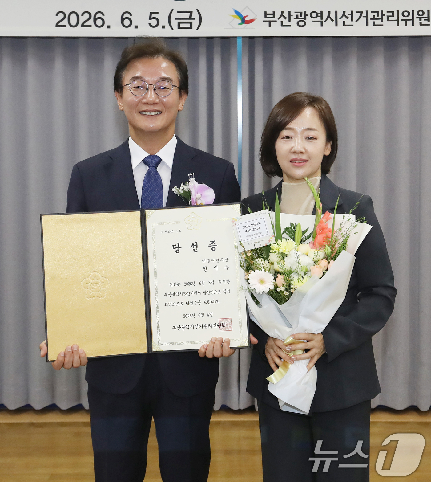 (부산=뉴스1) 윤일지 기자 = 전재수 부산시장 당선인이 5일 오후 부산 연제구 부산시선거관리위원회에서 열린 제9회 전국동시지방선거 당선증 교부식에서 당선증을 교부받은 뒤 배우자 …