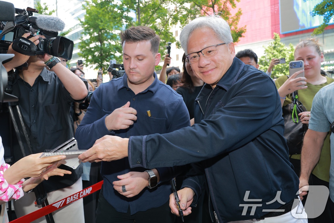 (서울=뉴스1) 이광호 기자 = 엔비디아 젠슨 황 최고경영자(CEO)가 5일 오후 서울 마포구 T1베이스 캠프를 방문하며 시민들에게 사인을 해주고 있다. (공동취재) 2026.6. …