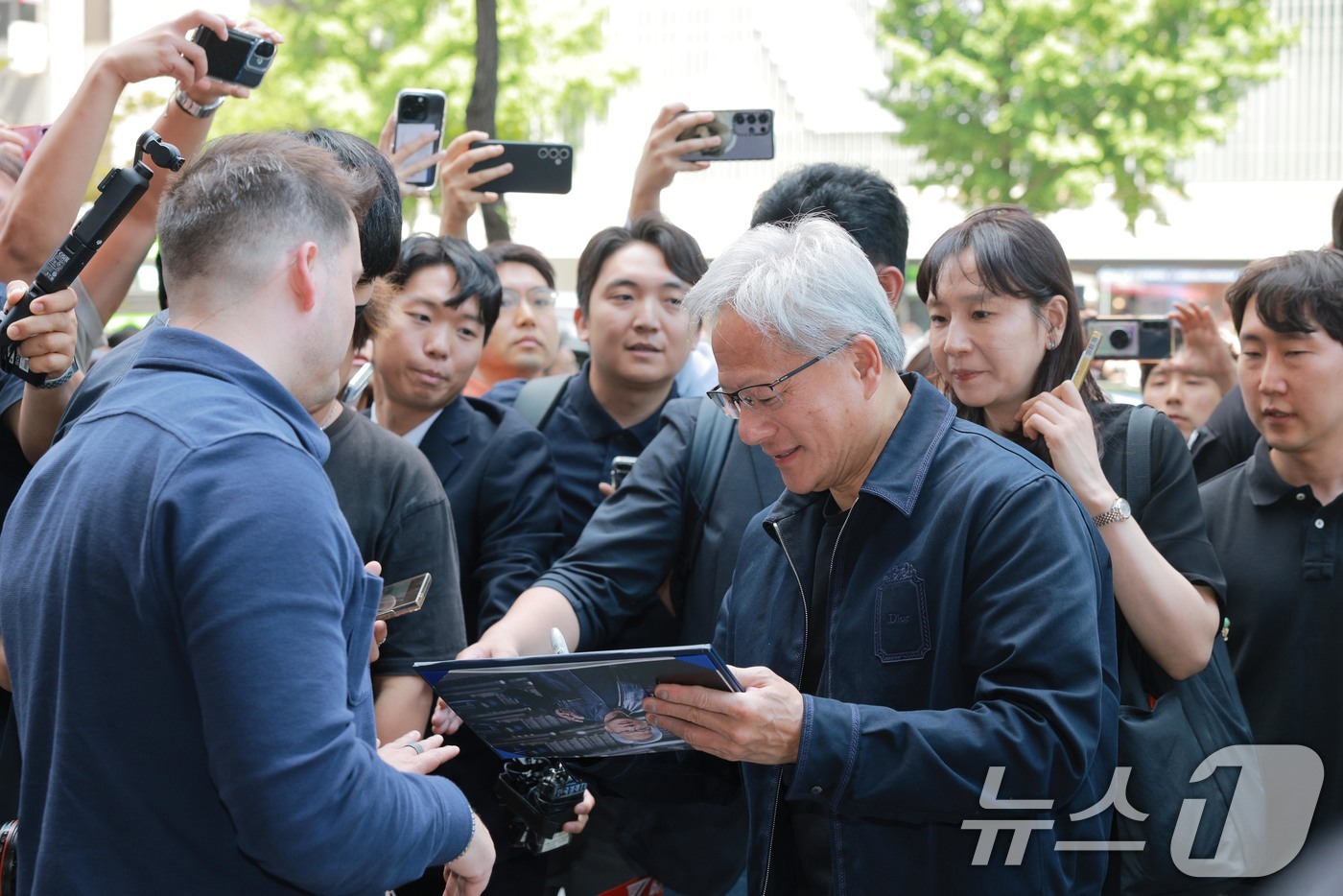(서울=뉴스1) 이광호 기자 = 엔비디아 젠슨 황 최고경영자(CEO)가 5일 오후 서울 마포구 T1베이스 캠프를 방문하며 시민들의 사인 요청에 응답하고 있다. (공동취재) 2026 …